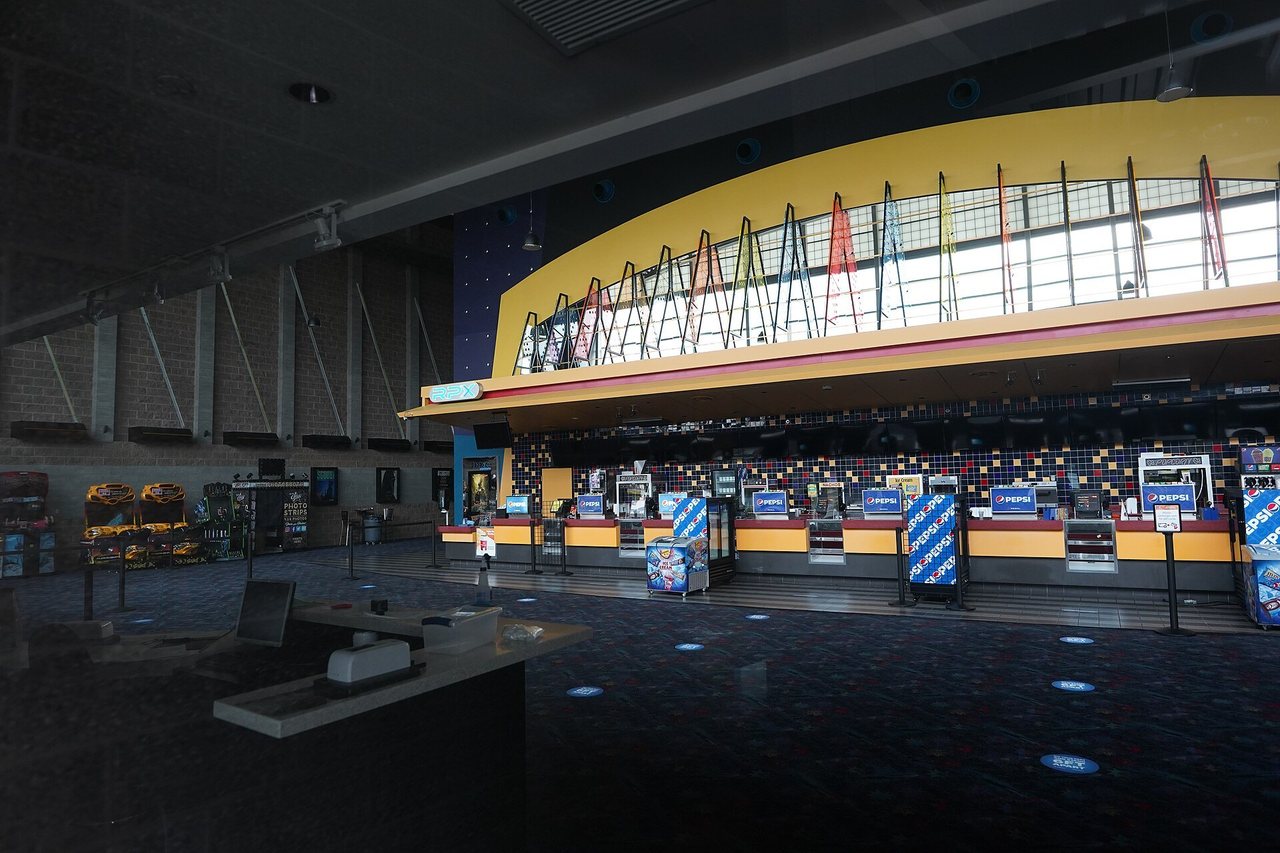 Интерьер кинотеатра IMAX с большим экраном и рядами кресел.